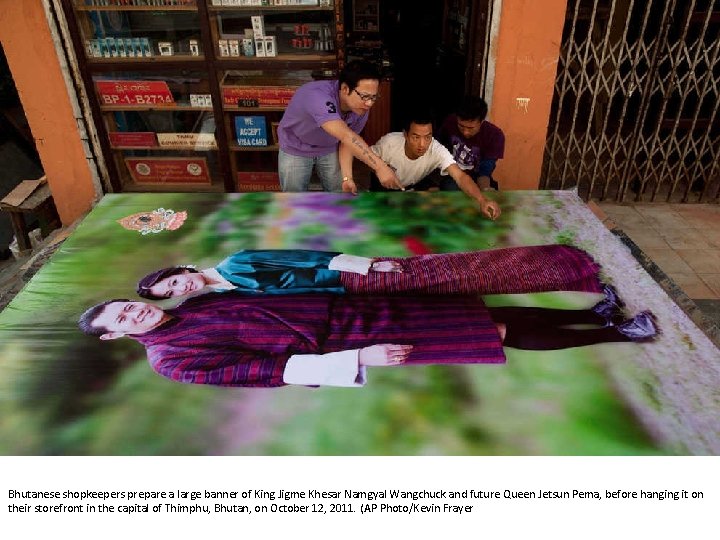 Bhutanese shopkeepers prepare a large banner of King Jigme Khesar Namgyal Wangchuck and future