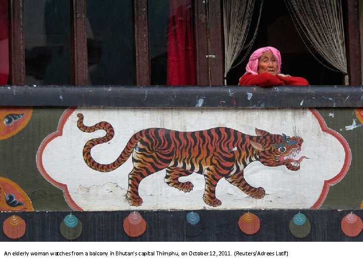 An elderly woman watches from a balcony in Bhutan's capital Thimphu, on October 12,