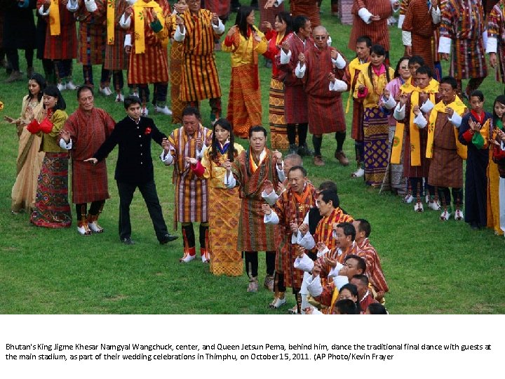 Bhutan's King Jigme Khesar Namgyal Wangchuck, center, and Queen Jetsun Pema, behind him, dance