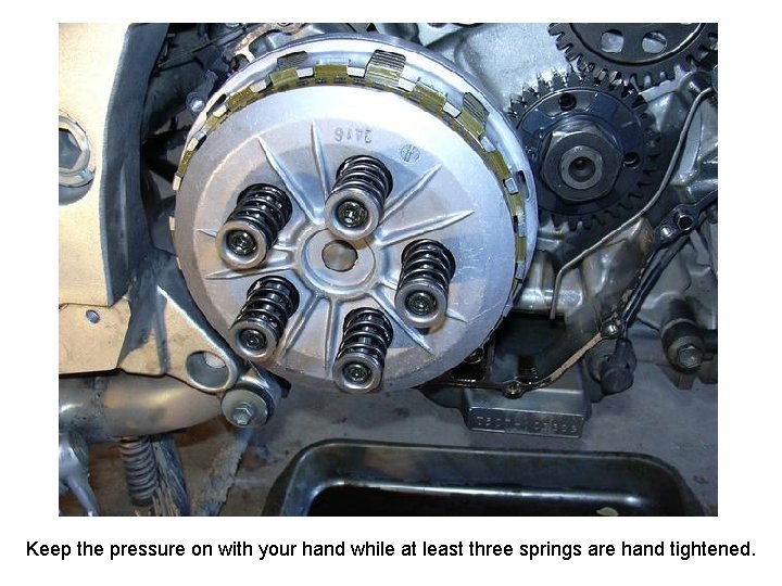 Keep the pressure on with your hand while at least three springs are hand