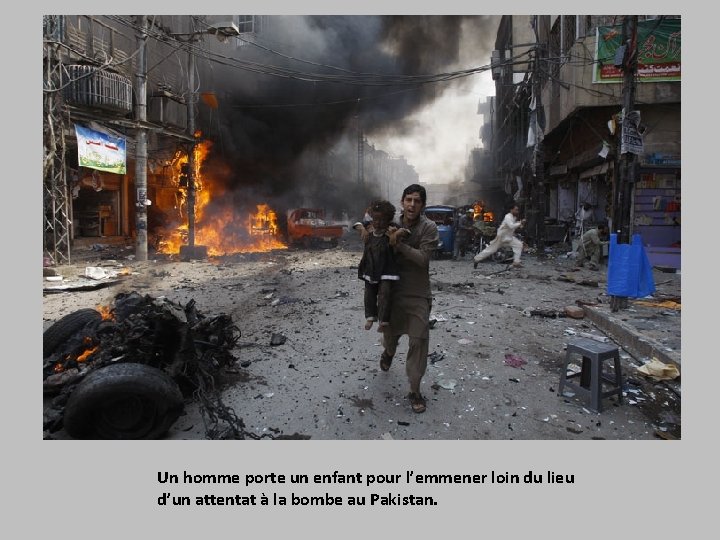 Un homme porte un enfant pour l’emmener loin du lieu d’un attentat à la