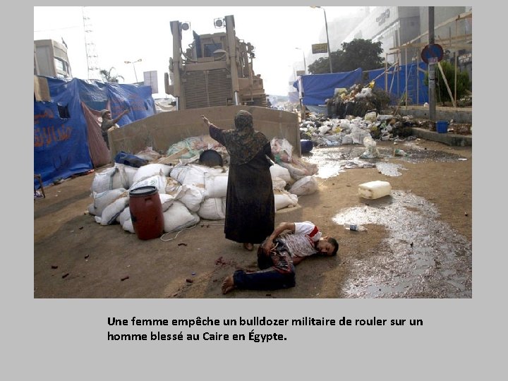 Une femme empêche un bulldozer militaire de rouler sur un homme blessé au Caire