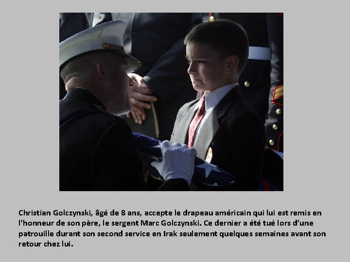 Christian Golczynski, âgé de 8 ans, accepte le drapeau américain qui lui est remis