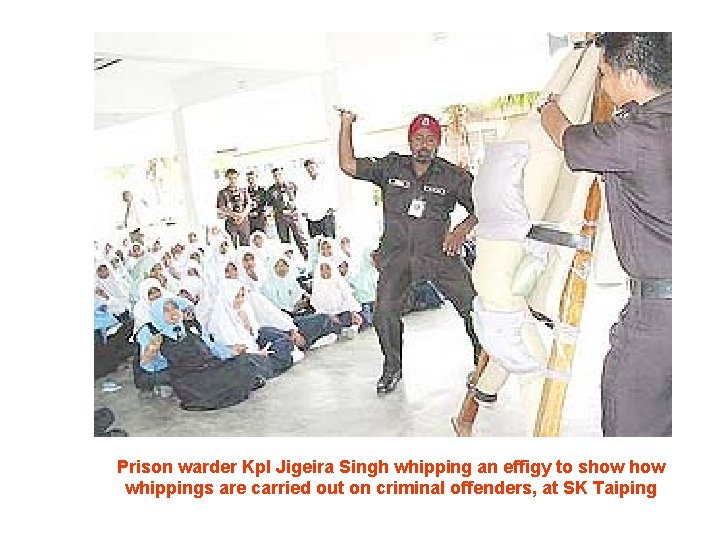 Prison warder Kpl Jigeira Singh whipping an effigy to show whippings are carried out