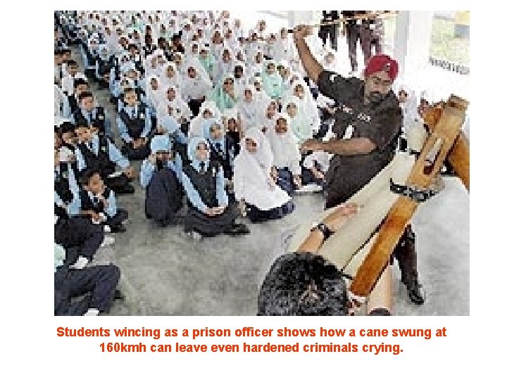 Students wincing as a prison officer shows how a cane swung at 160 kmh