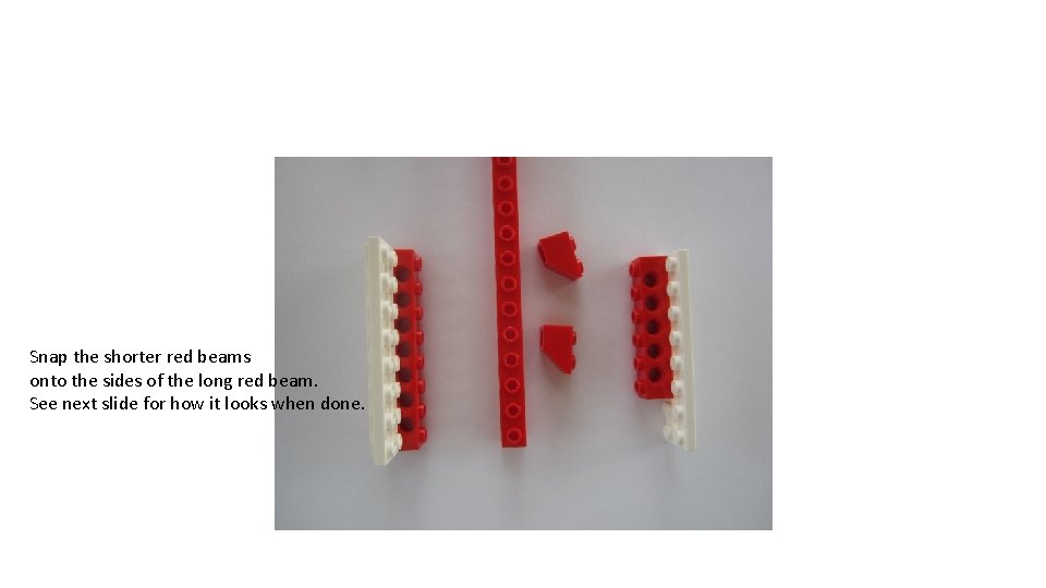 Snap the shorter red beams onto the sides of the long red beam. See