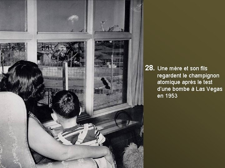 28. Une mère et son fils regardent le champignon atomique après le test d’une