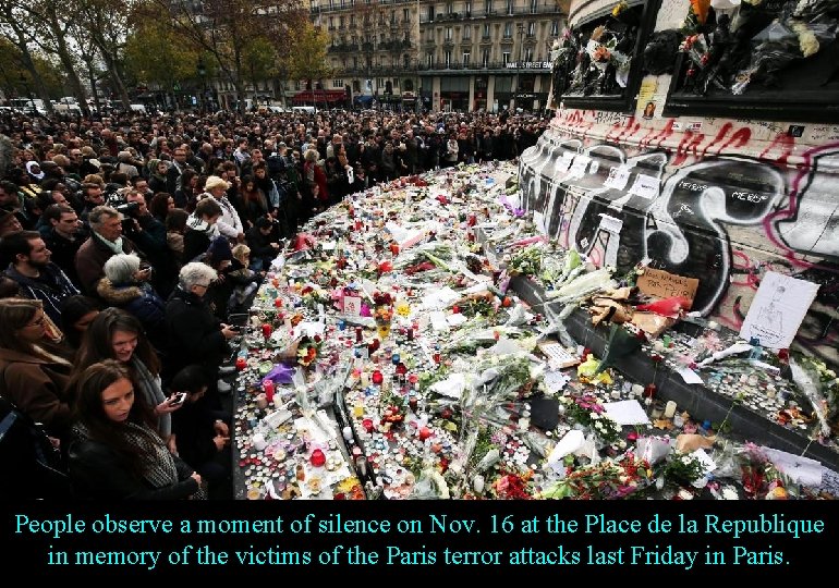 People observe a moment of silence on Nov. 16 at the Place de la