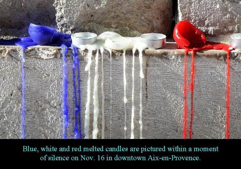 Blue, white and red melted candles are pictured within a moment of silence on