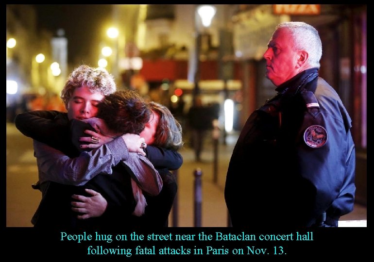 People hug on the street near the Bataclan concert hall following fatal attacks in