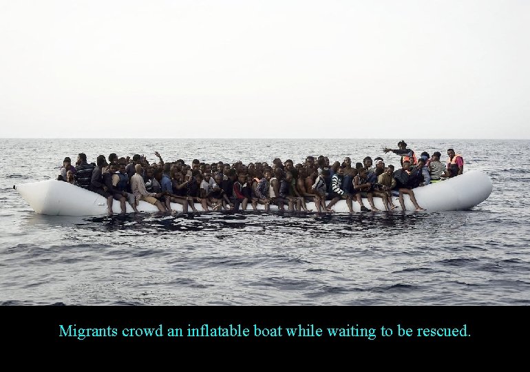 Migrants crowd an inflatable boat while waiting to be rescued. 