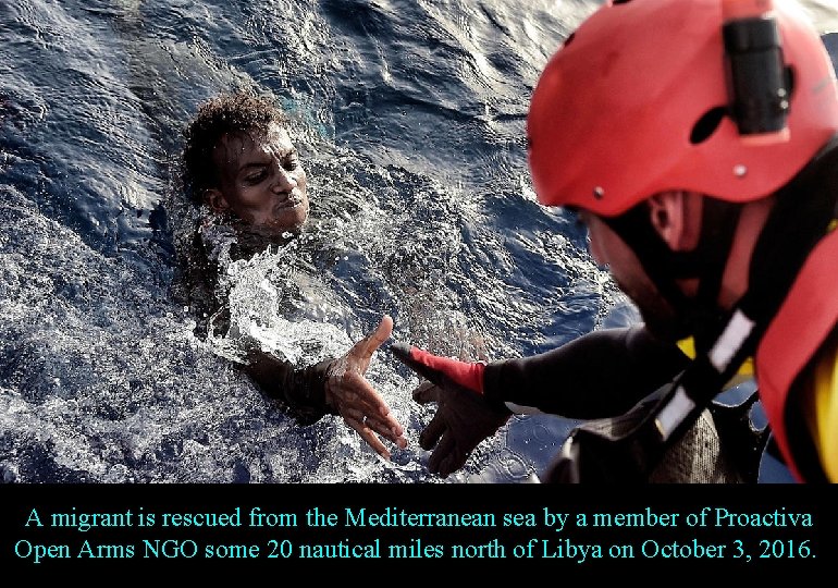 A migrant is rescued from the Mediterranean sea by a member of Proactiva Open
