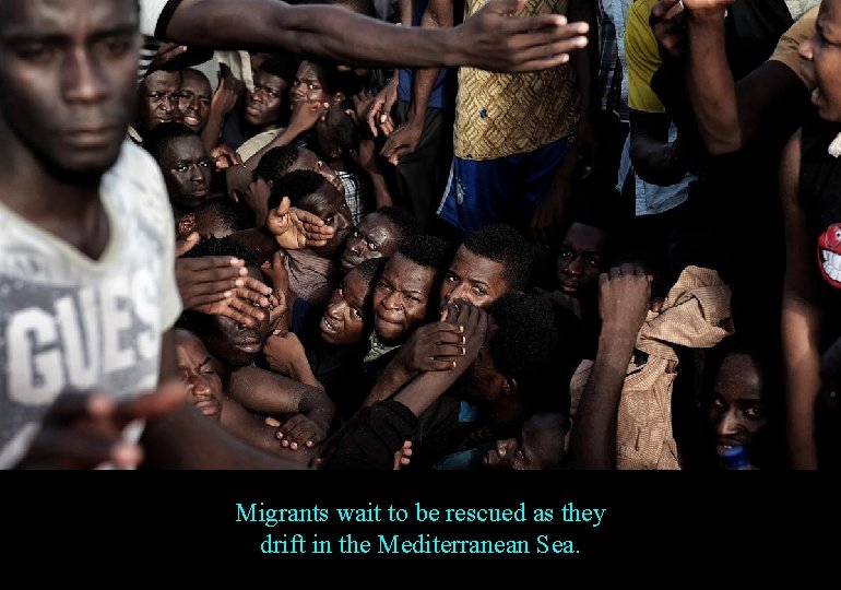 Migrants wait to be rescued as they drift in the Mediterranean Sea. 