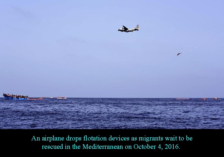 An airplane drops flotation devices as migrants wait to be rescued in the Mediterranean