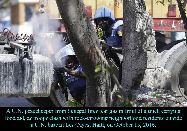 A U. N. peacekeeper from Senegal fires tear gas in front of a truck