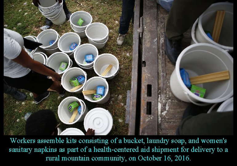 Workers assemble kits consisting of a bucket, laundry soap, and women's sanitary napkins as