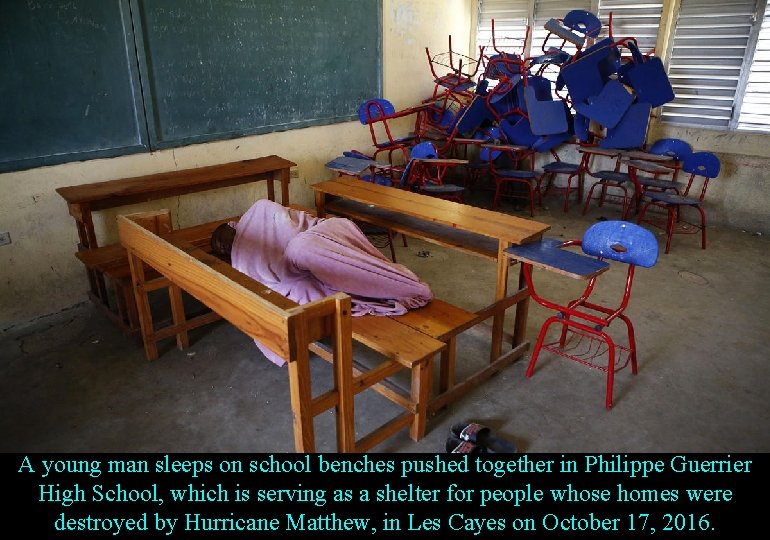 A young man sleeps on school benches pushed together in Philippe Guerrier High School,