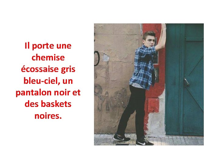 Il porte une chemise écossaise gris bleu-ciel, un pantalon noir et des baskets noires.