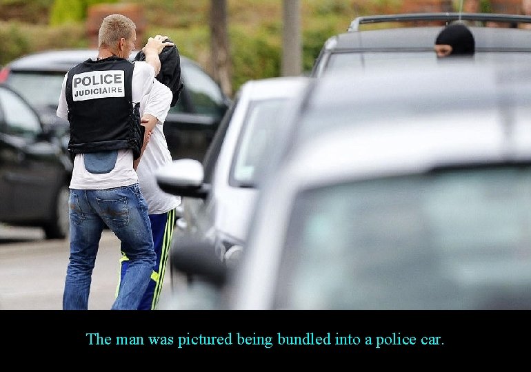 The man was pictured being bundled into a police car. 