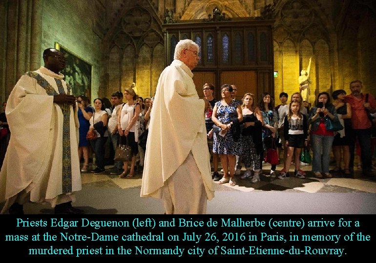 Priests Edgar Deguenon (left) and Brice de Malherbe (centre) arrive for a mass at