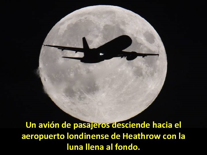 Un avión de pasajeros desciende hacia el aeropuerto londinense de Heathrow con la luna