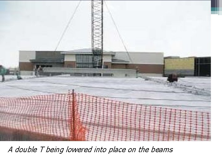 A double T being lowered into place on the beams 