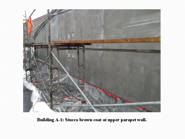 Building A-1: Stucco brown coat at upper parapet wall. 