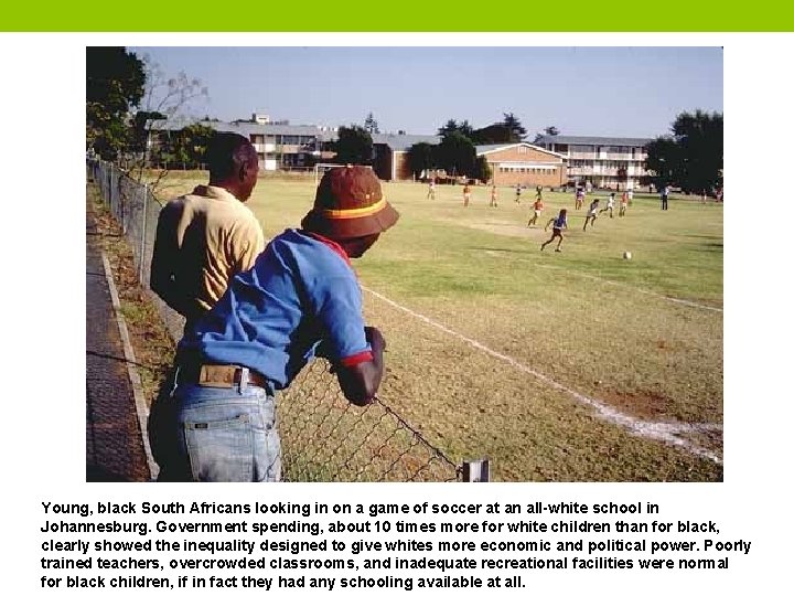 Young, black South Africans looking in on a game of soccer at an all-white