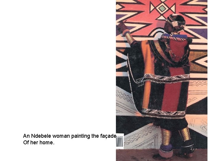 An Ndebele woman painting the façade Of her home. 