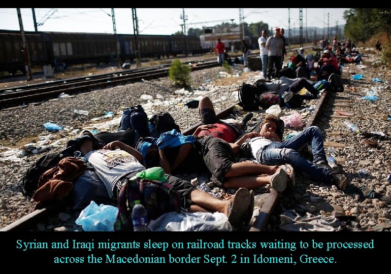 Syrian and Iraqi migrants sleep on railroad tracks waiting to be processed across the