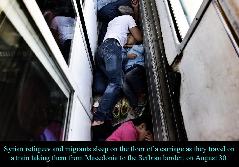 Syrian refugees and migrants sleep on the floor of a carriage as they travel