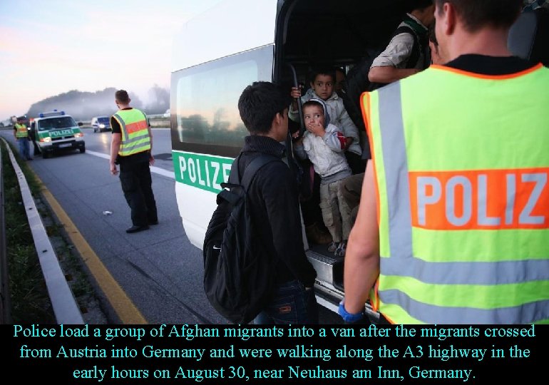 Police load a group of Afghan migrants into a van after the migrants crossed