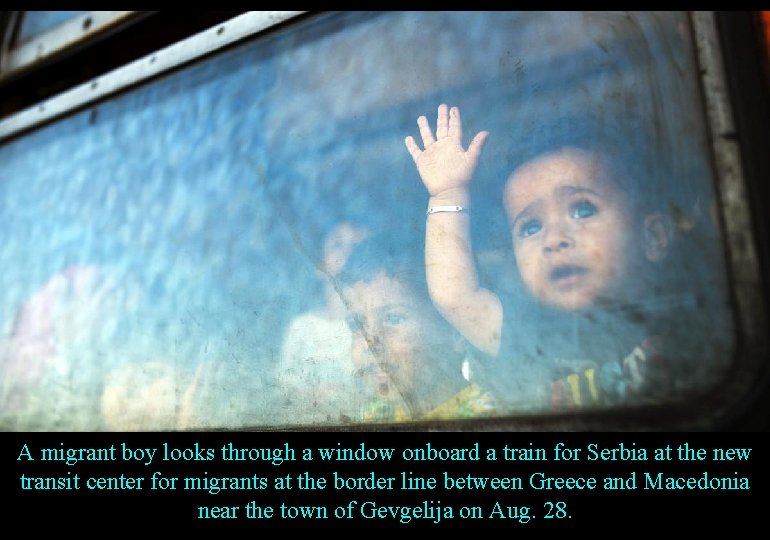 A migrant boy looks through a window onboard a train for Serbia at the