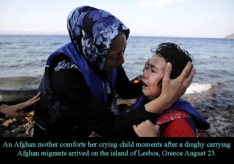 An Afghan mother comforts her crying child moments after a dinghy carrying Afghan migrants