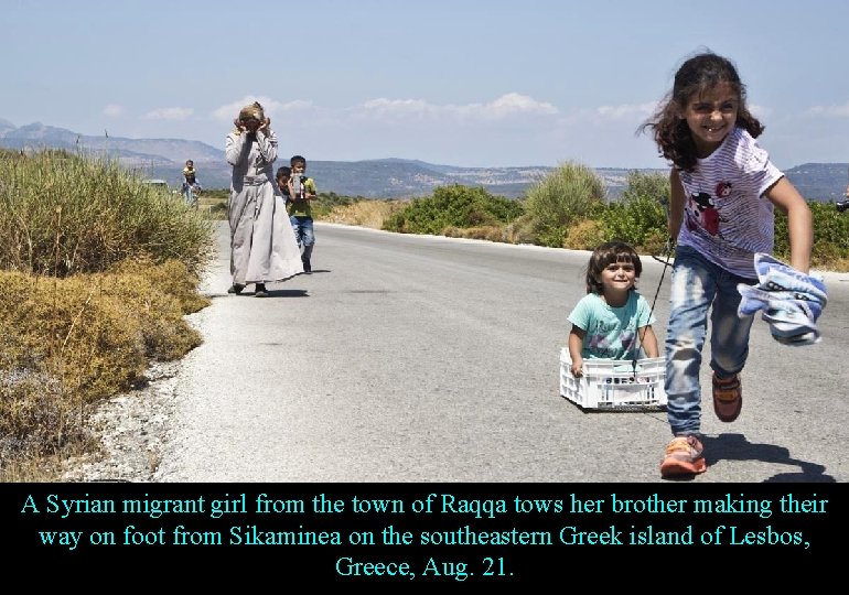 A Syrian migrant girl from the town of Raqqa tows her brother making their