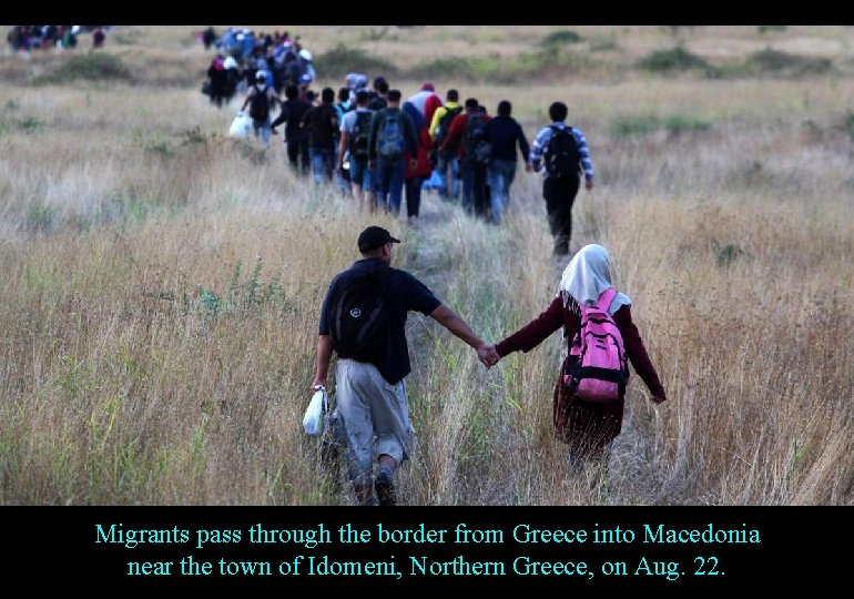 Migrants pass through the border from Greece into Macedonia near the town of Idomeni,