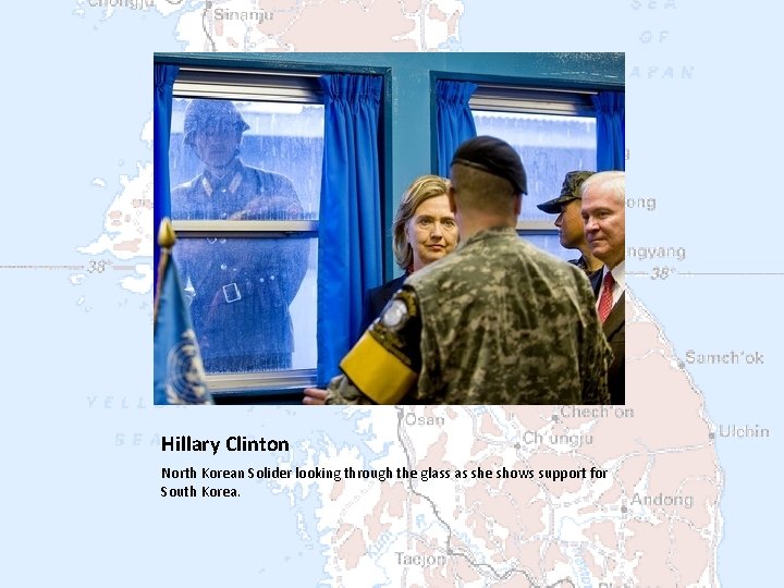 Hillary Clinton North Korean Solider looking through the glass as she shows support for