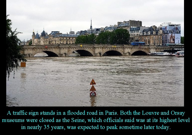 A traffic sign stands in a flooded road in Paris. Both the Louvre and