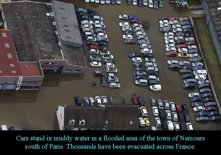 Cars stand in muddy water in a flooded area of the town of Nemours