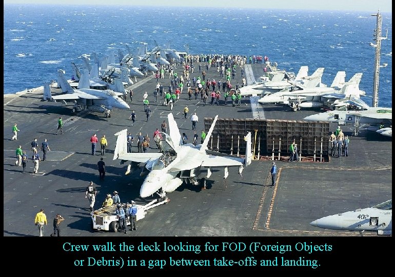 Crew walk the deck looking for FOD (Foreign Objects or Debris) in a gap