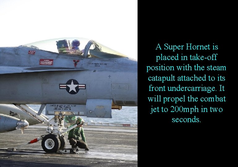 A Super Hornet is placed in take-off position with the steam catapult attached to