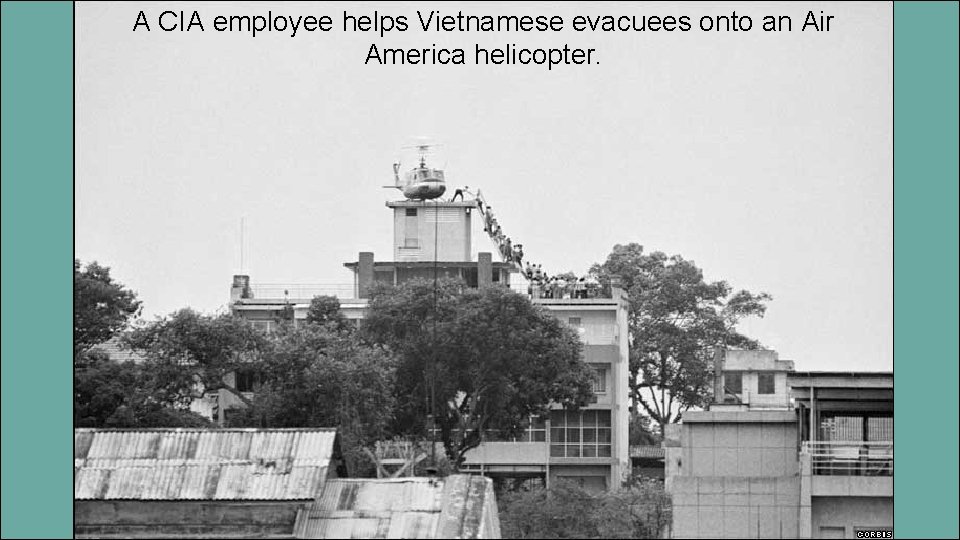 A CIA employee helps Vietnamese evacuees onto an Air America helicopter. 