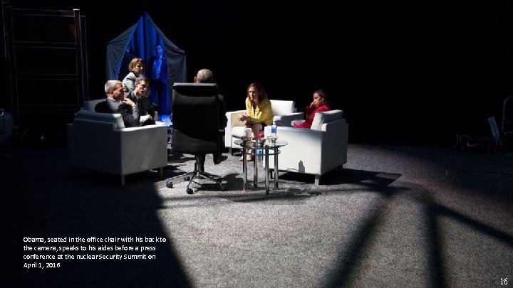 Obama, seated in the office chair with his back to the camera, speaks to