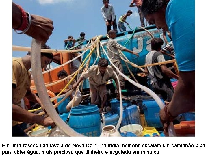 Em uma ressequida favela de Nova Délhi, na Índia, homens escalam um caminhão-pipa para