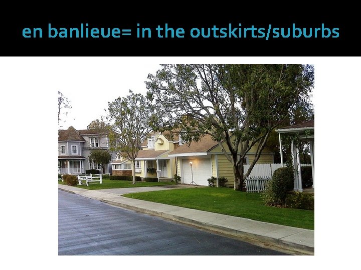 en banlieue= in the outskirts/suburbs 