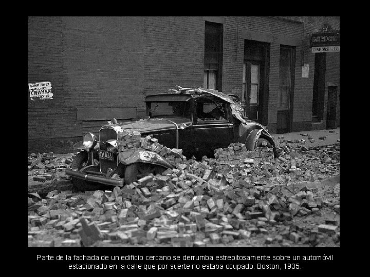 Parte de la fachada de un edificio cercano se derrumba estrepitosamente sobre un automóvil