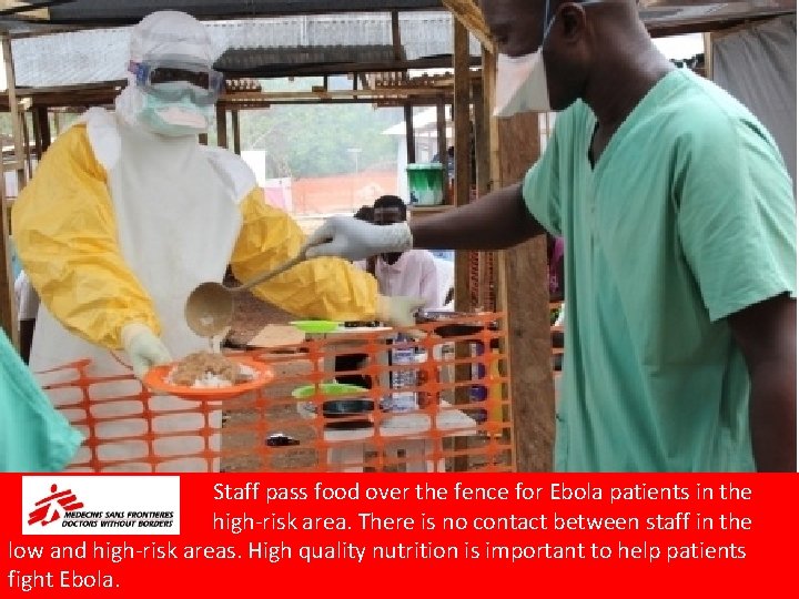 Staff pass food over the fence for Ebola patients in the high-risk area. There