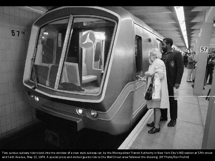 Two curious subway riders look into the window of a new style subway car,