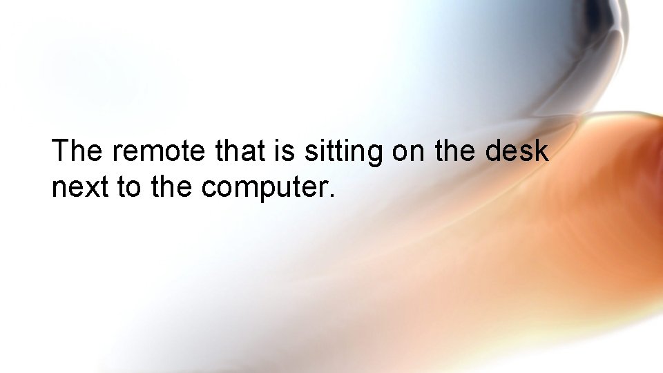 The remote that is sitting on the desk next to the computer. 