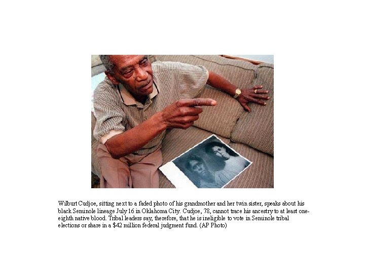 Wilburt Cudjoe, sitting next to a faded photo of his grandmother and her twin